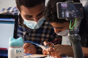 two LYBOTICS participants work on a circuitboard