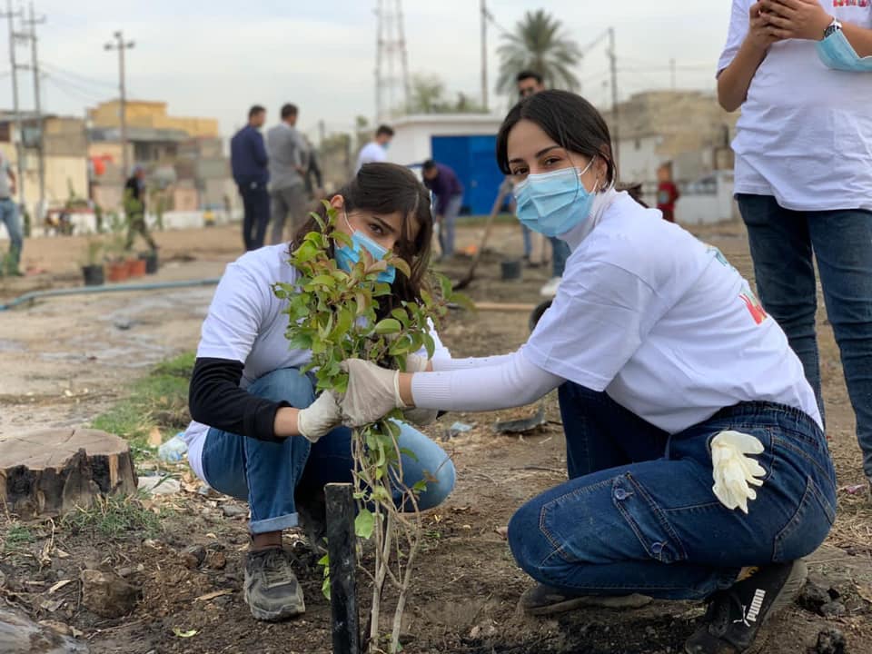 two girls plant a tree during a Better World Organization event