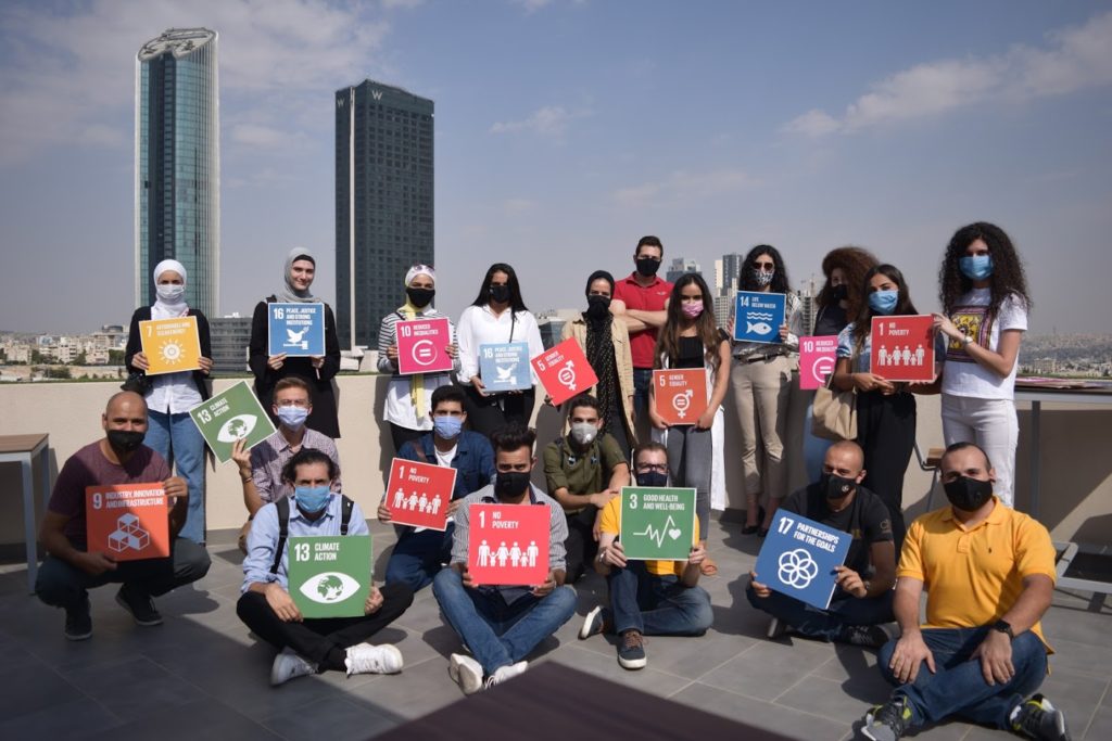 the IYAF team holding up signs for each of the SDGs